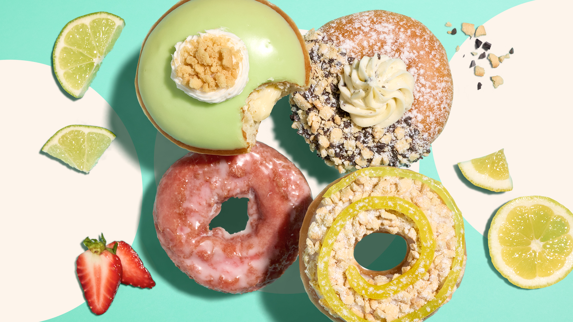 four fruit flavored doughnuts with limes, lemons and strawberries